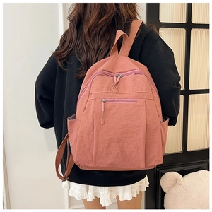 Water-resistant nylon backpack in lotus pink shown from the back on a model