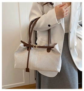 Detailaufnahme der Kontrastleder-Verzierung und Schnalle an einem großen Canvas-Shopper