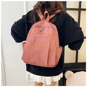 Rear view of a model wearing the water-resistant nylon backpack in a vintage red finish