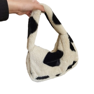 Faux fur hobo tote bag featuring a stylish black and white cow print and hobo silhouette