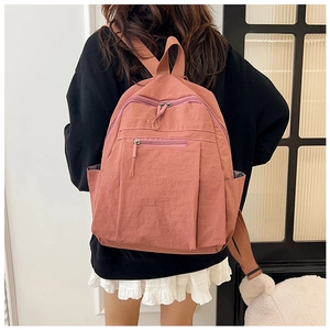 Detail shot of a water-resistant pink nylon backpack for daily travel and commuting