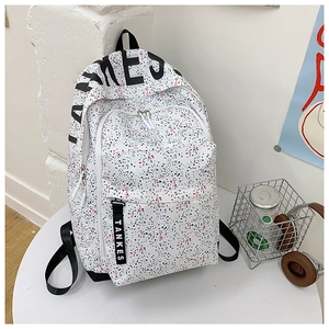 Close-up of white canvas backpack with pink and black ink splash texture and TANKES logo