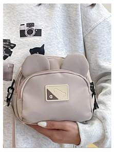 Detail of cute bear crossbody bag with ears and adjustable strap in beige nylon