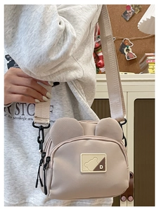 Detailed macro view of the beige teddy bear crossbody bag with cute 3D ears and logo