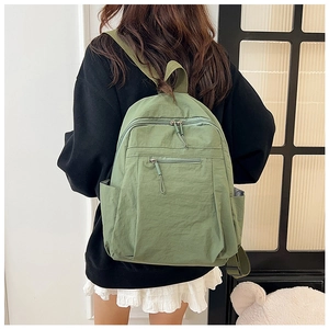 Rear view of a sage green water-resistant nylon backpack for casual travel and commute