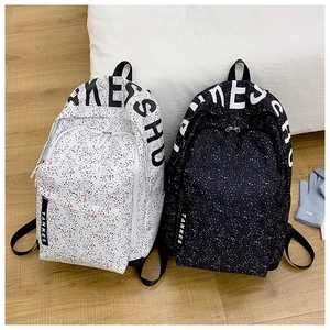 Detail of black and white star patterned backpacks with decorative lettering straps