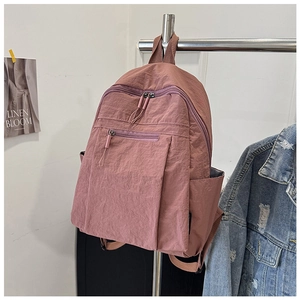 Detailed view of the water-resistant pink nylon backpack with multiple compartments