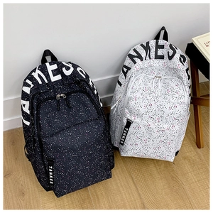Detail view of TANKES backpacks in black and white with star patterns and logo