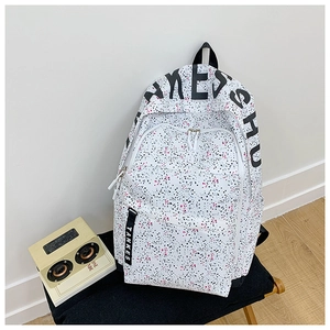 Detail of causal backpack featuring trendy splatter patterns and branded textile straps