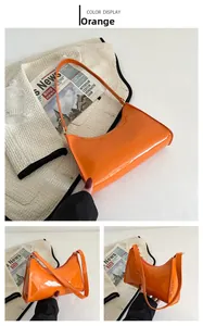 Détails du sac sous le bras en cuir verni orange avec fermeture éclair et bandoulière