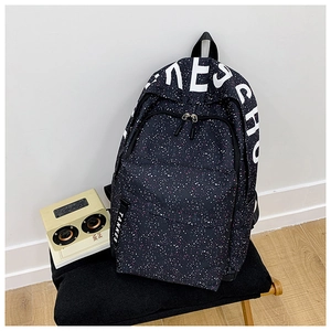 Detail view of large capacity black backpack with paint splatter and side webbing