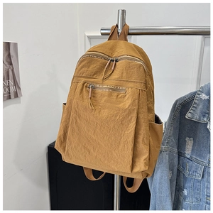 Detail view of water-resistant ginger nylon backpack with multiple zipper pockets