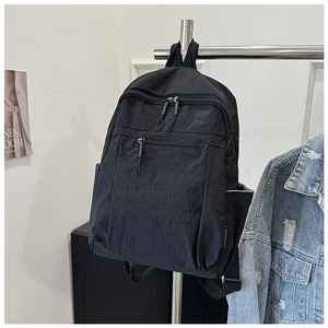 Detail view of water-resistant black nylon backpack with multiple functional pockets
