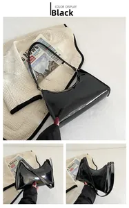 Vue détaillée du sac baguette en cuir verni noir montrant la texture brillante et boucle
