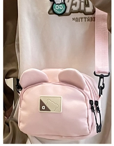 Detail of pink nylon crossbody bag with cute bear ears and adjustable shoulder strap