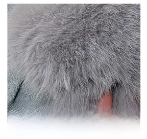 Gros plan sur le col en fausse fourrure grise d'une veste en jean bleu clair délavé