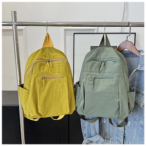 Detail of yellow and green water-resistant nylon backpacks on display stands