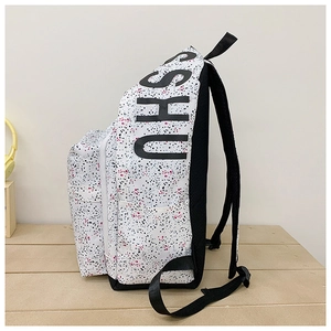 Detail view of canvas backpack side with SHU lettering and ink splatter pattern