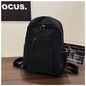 Detail showing water-resistant black nylon backpack with multiple pockets and sturdy straps