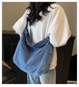 Sac cabas en denim bleu avec large bandoulière, vue arrière sur un mannequin féminin