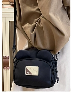 Close-up of cute black bear-themed crossbody canvas bag with round ear decor and D patch