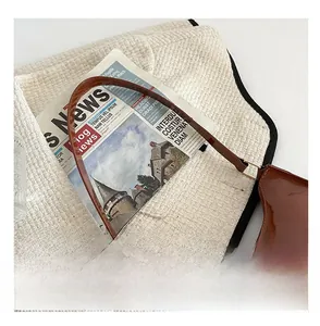 Détail de la texture en cuir verni marron et ferrures dorées sur un sac baguette français