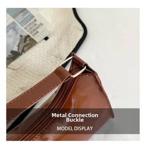 Gros plan du sac sous le bras en cuir marron brillant avec boucles en métal doré poli