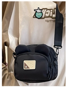 Detail view of black nylon crossbody bag with cute 3D bear ears and adjustable wide strap