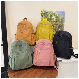 Detailed display of five colorful water-resistant nylon backpacks in a modern minimalist style