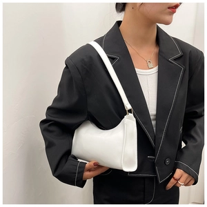 Sac hobo moderne en cuir PU blanc porté avec un blazer noir pour un look minimaliste