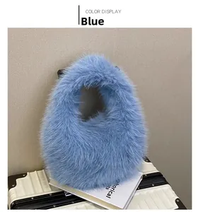 Détail d'un sac à main en fausse fourrure bleu clair posé sur une valise blanche chic