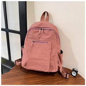 Close-up of water-resistant nylon backpack showing front pocket and side pocket detail
