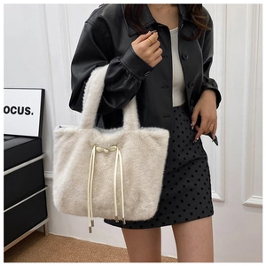 Detail of off-white faux fur tote bag showing soft texture and metal-tipped drawstrings