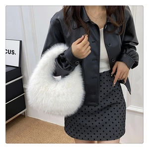 Détail de la texture douce du sac à main blanc en fausse fourrure sur le mannequin
