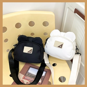 Detail showing cute bear ear design on small canvas crossbody bags in black and white