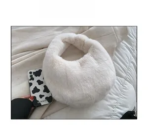 Size comparison of a white fluffy faux fur handbag next to a cow print smartphone case