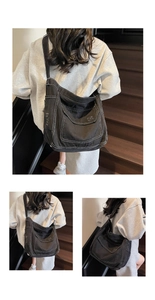 Gros plan sur un sac en denim noir avec coutures blanches contrastées et bords effilochés