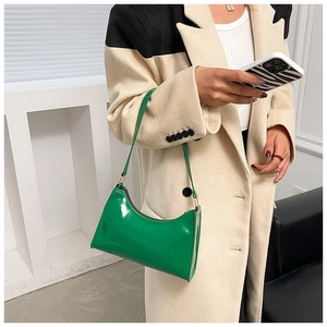 Détail du sac en cuir verni vert émeraude avec finition brillante et design incurvé