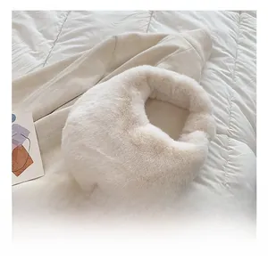 Close-up of soft beige faux fur handbag with plush texture and minimalist cloud shape design