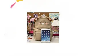 Detailed view of the khaki bear backpack showing plush ears and front zipper pocket