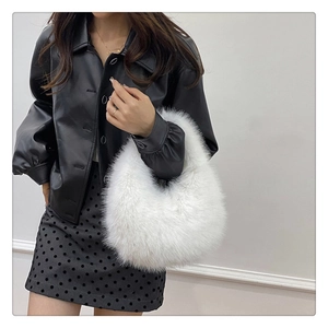 Détail de la texture douce d'un sac à main en fausse fourrure blanche de forme croissant