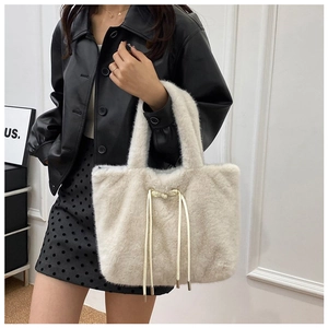 Close-up of fluffy cream plush tote bag featuring drawstring detail and soft winter texture