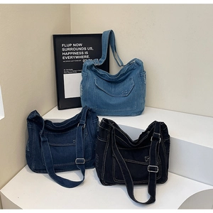 Détail des sacs cabas en denim vintage de couleurs bleu clair, bleu foncé et noir