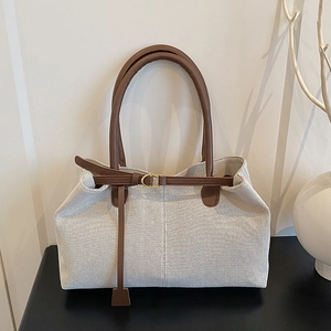 Retro Canvas-Tragetasche mit braunen Ledergriffen und Gold-Schnalle auf minimalistischem Tisch