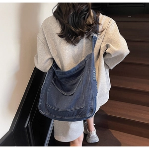 Détail du grand sac messager en denim avec bords effilés et large bandoulière réglable