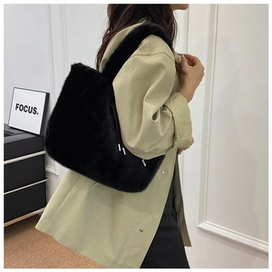 Side view of a large black faux fur tote bag showing the thick plush texture on a model