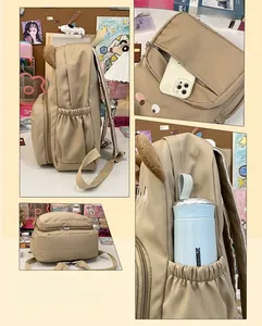 Detail of khaki nylon backpack featuring cute plush bear ears and side elastic cup pocket
