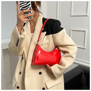 Vue détaillée d'un sac hobo en cuir verni rouge avec forme en croissant et fini brillant