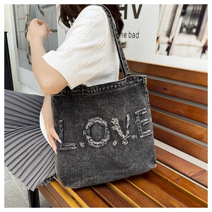 Detail of deep gray washed denim tote bag with LOVE letter patch embroidery