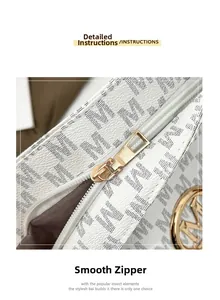 Detail of smooth gold zipper and monogram pattern on white commuter tote bag